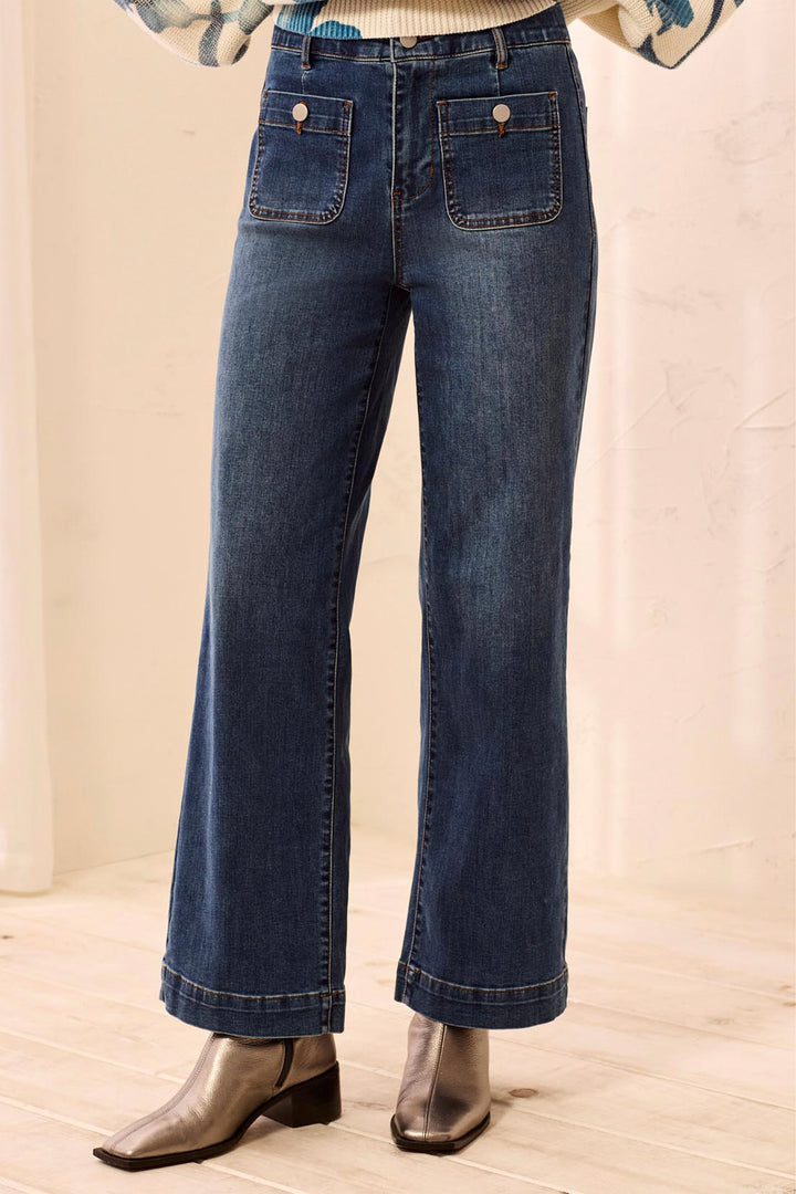 Blue jeans worn by a person on a beige background