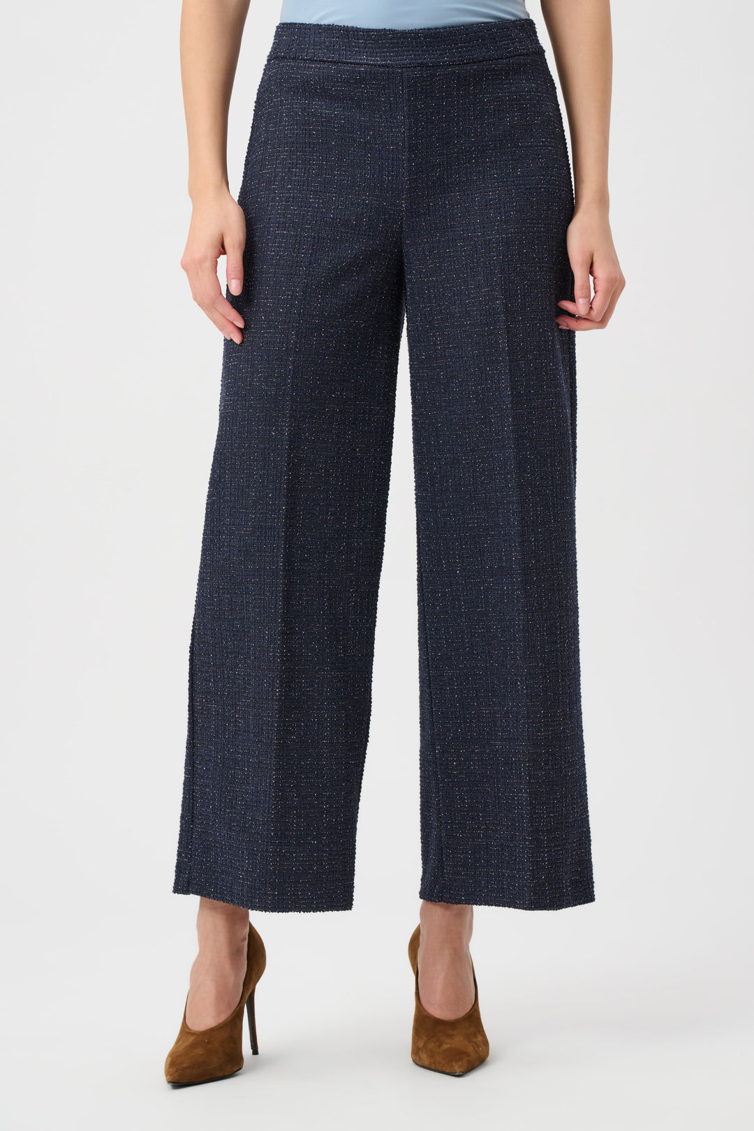 Person wearing dark blue wide-leg pants on a white background