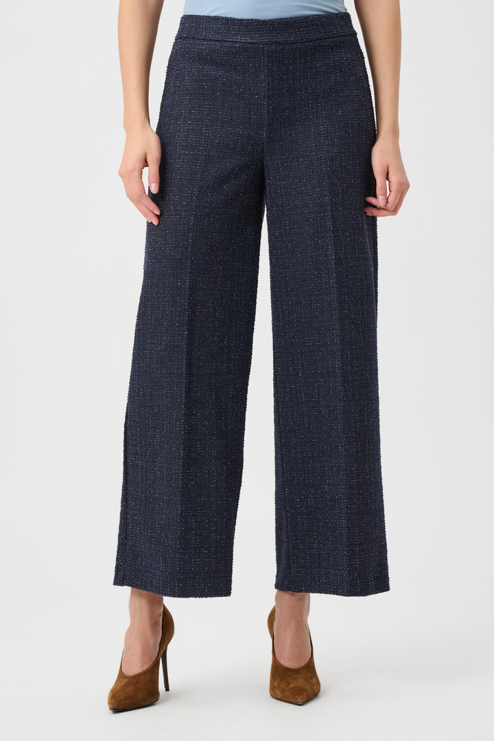 Person wearing dark blue wide-leg pants on a white background