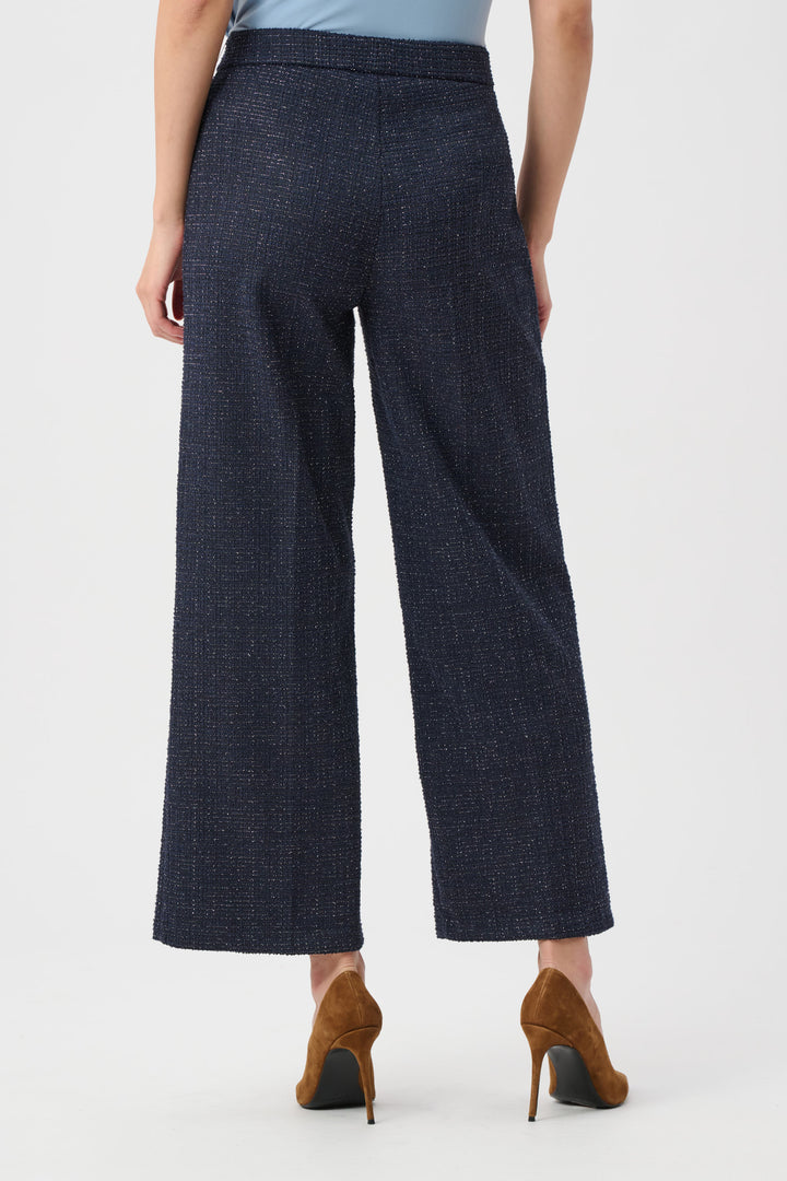 Person wearing dark blue checkered pants on a white background