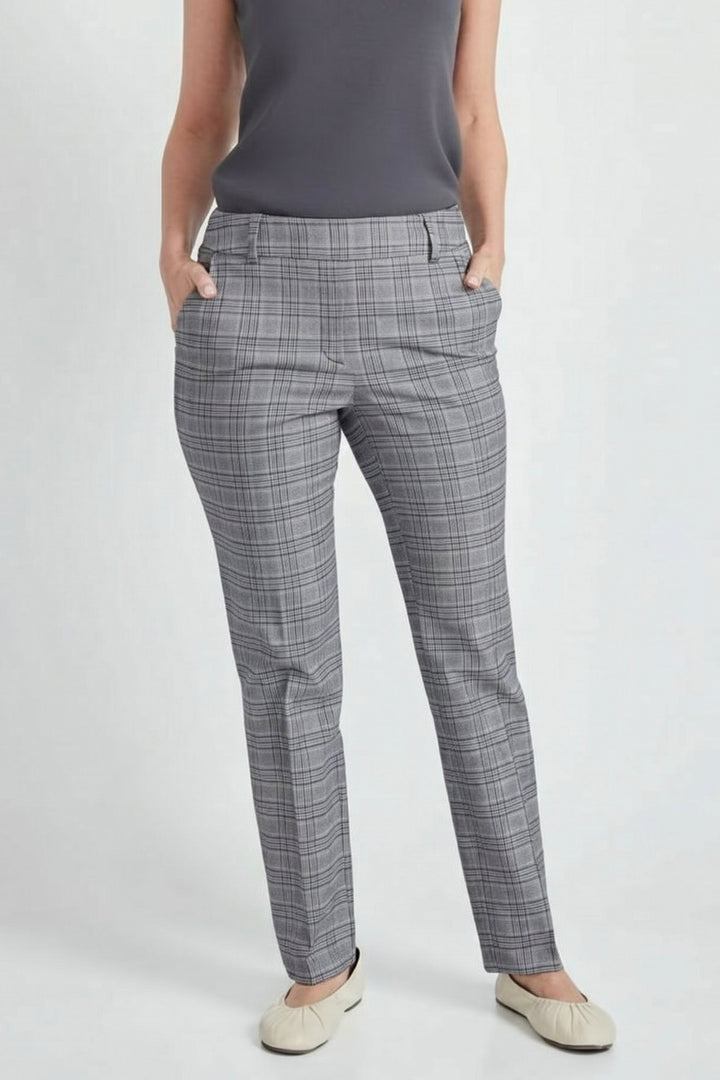 A model wearing gray plaid trousers, paired with a dark gray sleeveless top and beige flat shoes, shown from the waist down against a light gray studio background.