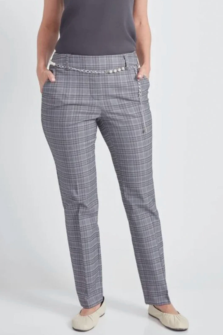 A model wearing gray plaid trousers with a decorative silver chain belt, paired with a dark gray top and beige flats, shown from the waist down against a light gray studio background.