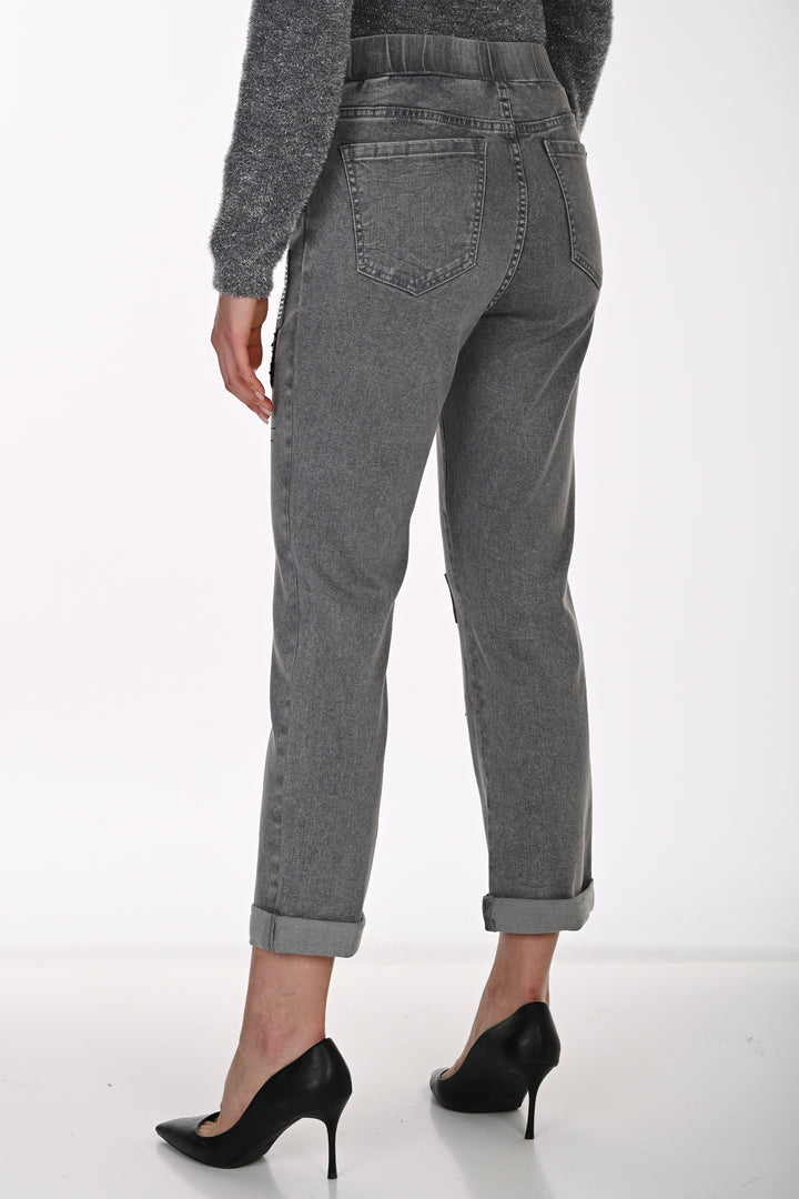 A person shown from the back wearing gray high-waisted cropped jeans with rolled cuffs and black pointed-toe heels against a clean white studio background.