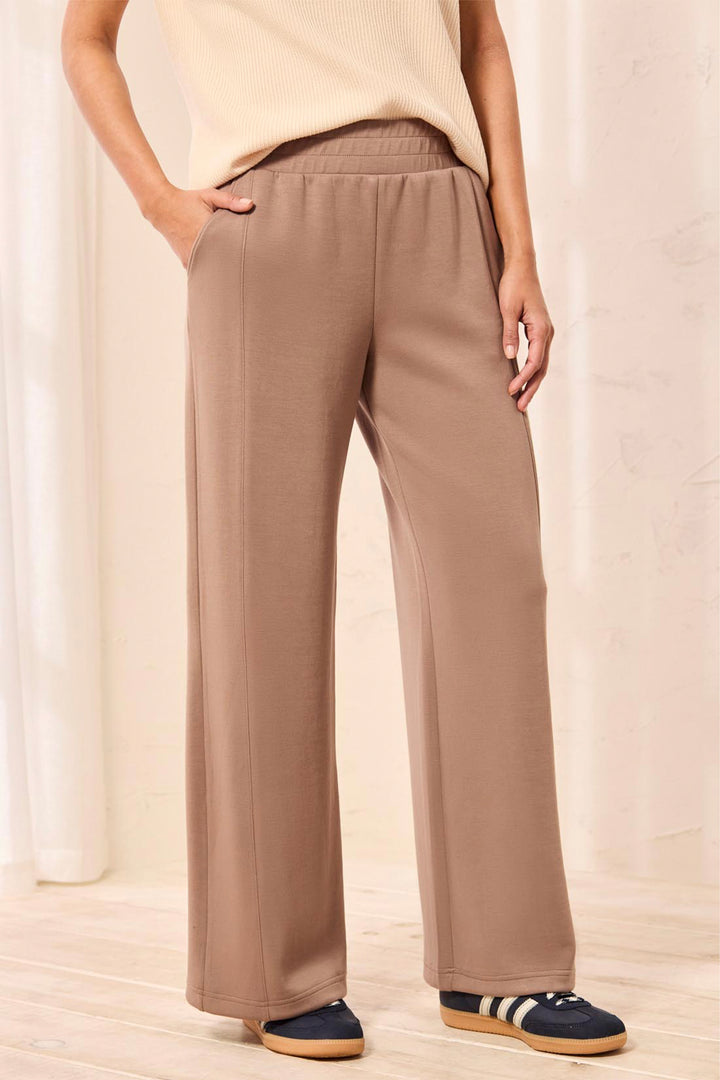 Person wearing beige wide-leg pants with a neutral background