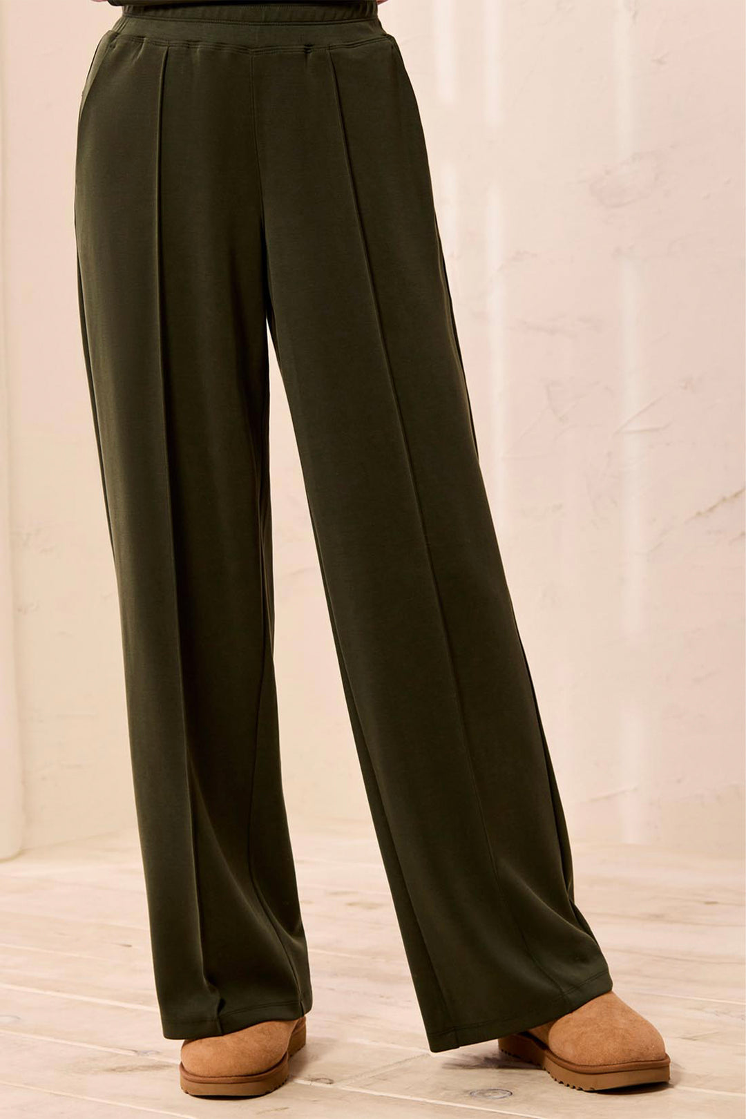 Dark green wide-leg pants on a neutral background