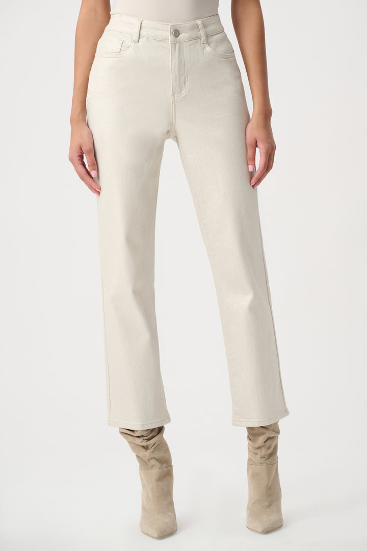 A woman modelling a white pair of metallic jeans with a pink sweater. 