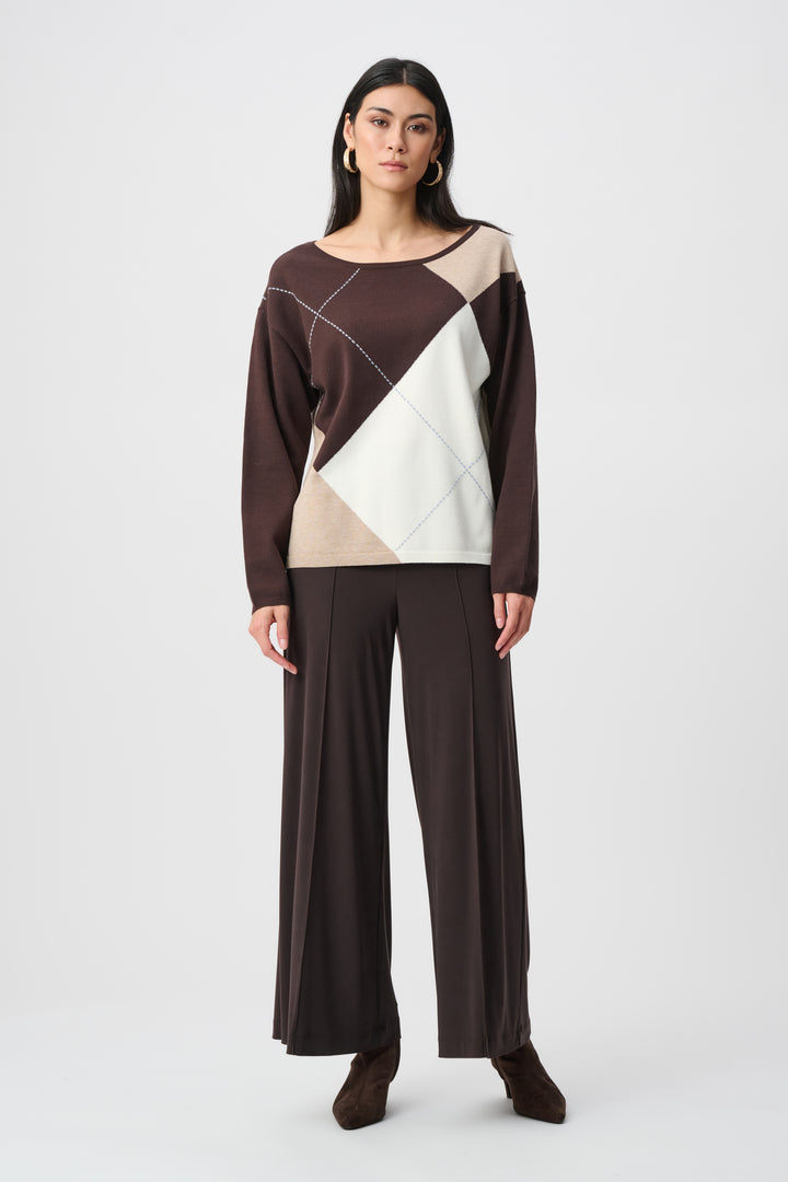 Woman wearing a brown and beige geometric-patterned top with wide-leg pants on a white background