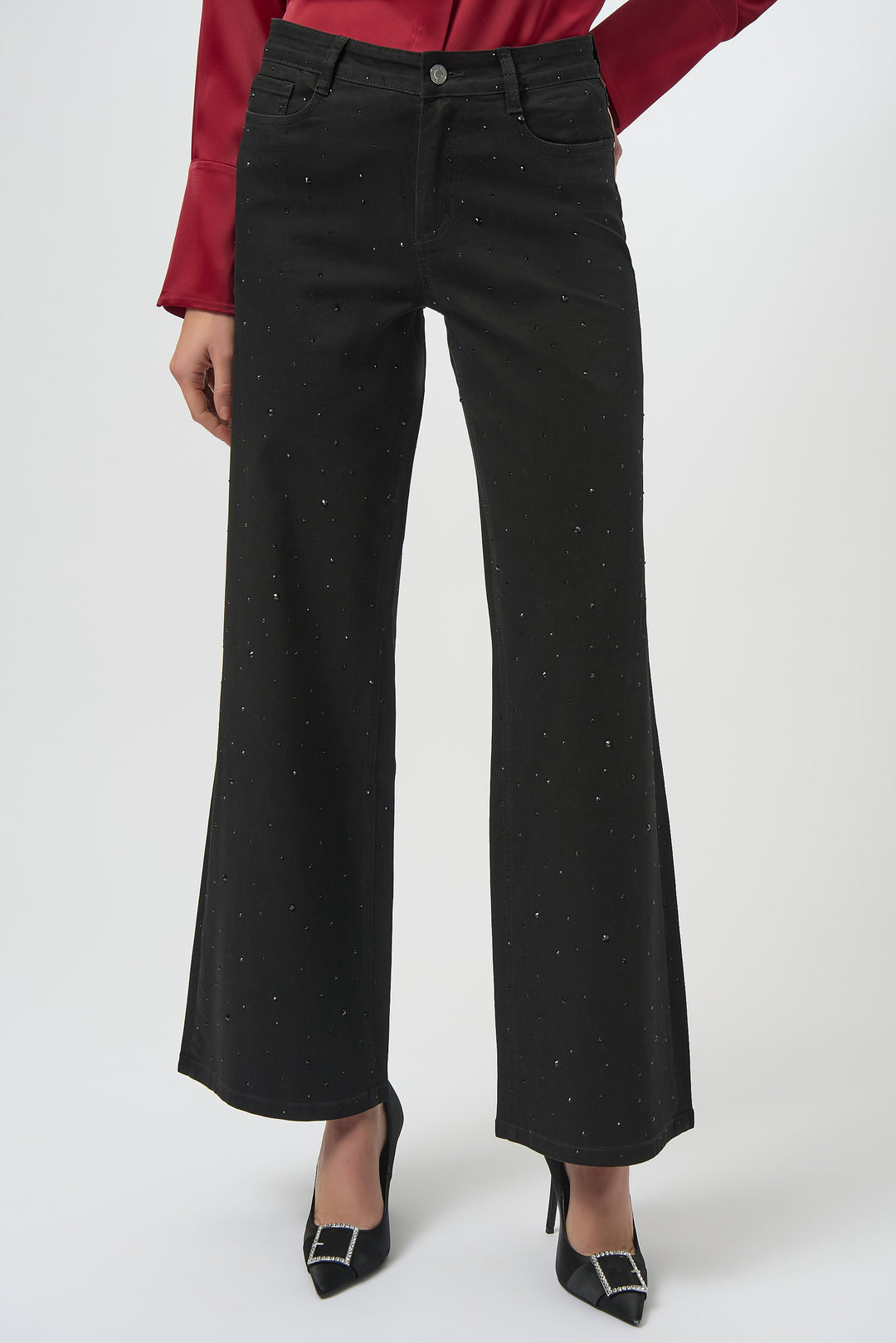 Black wide-leg pants with rhinestone studs worn by a person on a white background