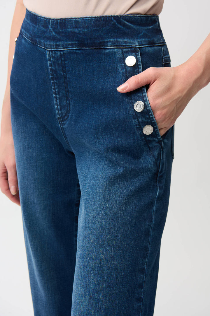 Blue jeans with button details on a plain background