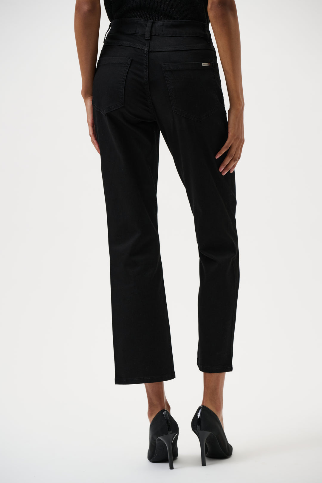 Black jeans worn by a person on a white background