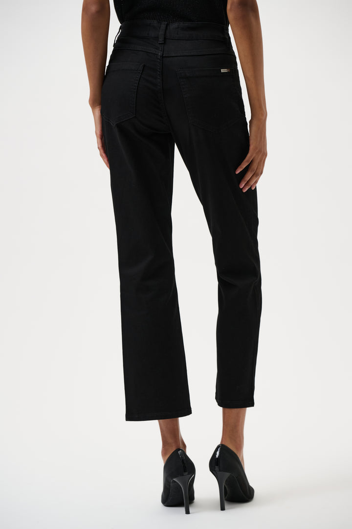 Black jeans worn by a person on a white background