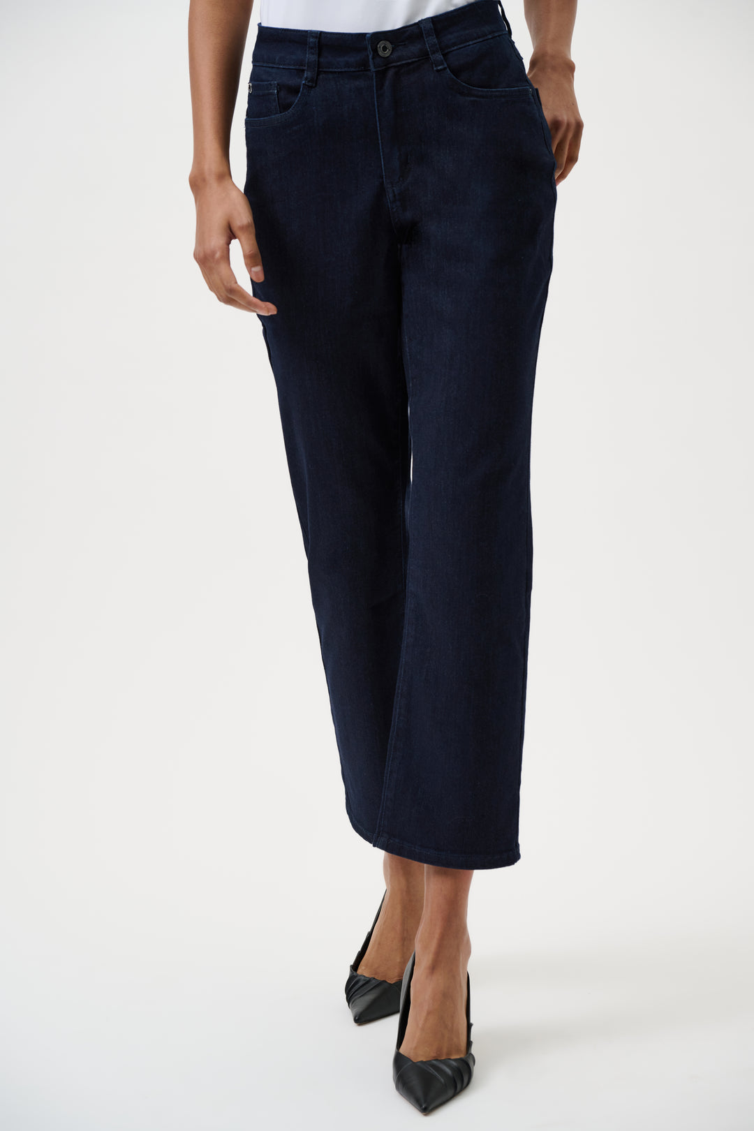 Navy blue jeans worn by a woman on a white background