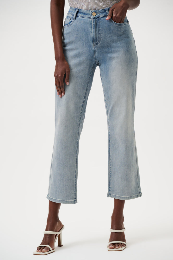 Person wearing light blue jeans on a white background