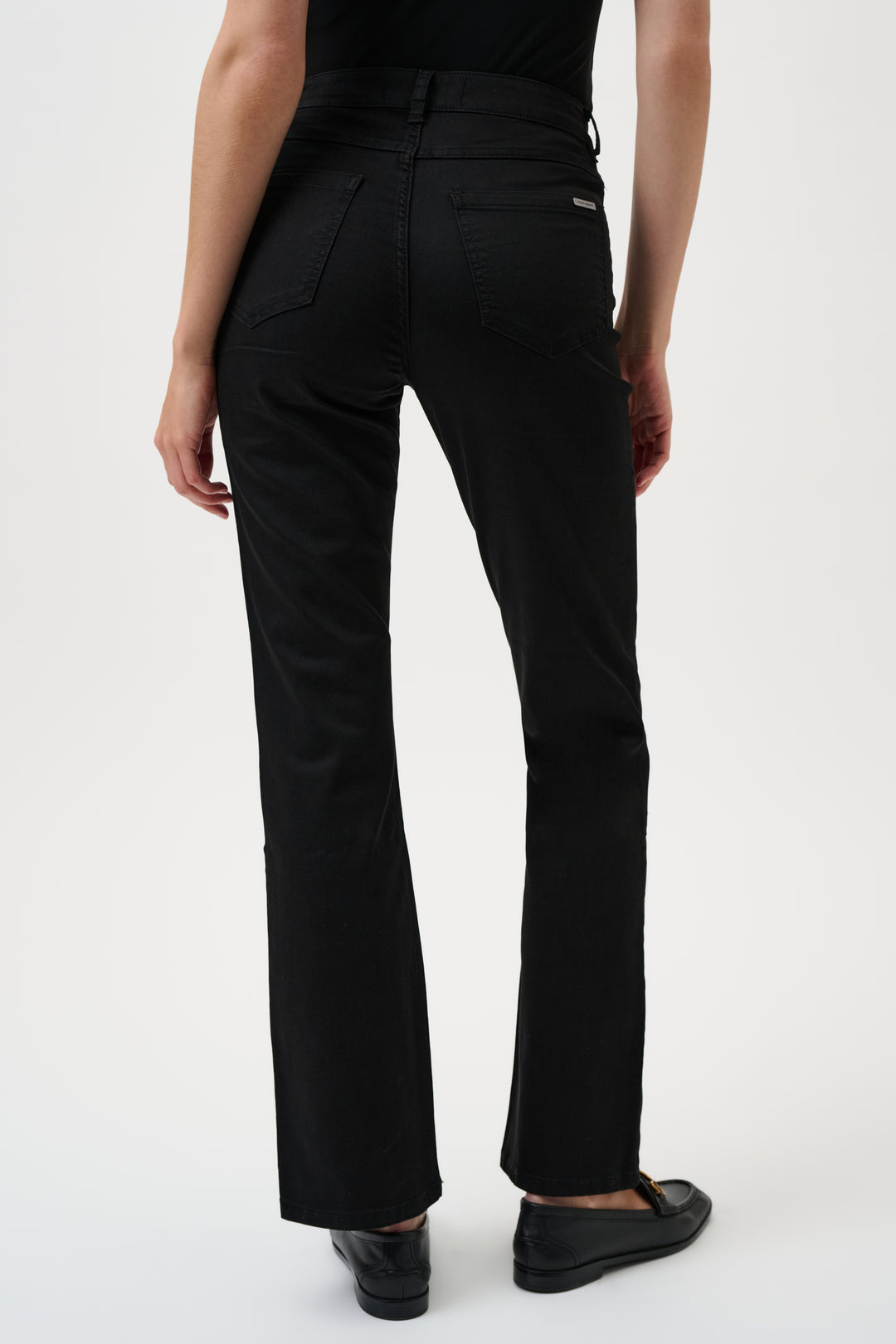 Black jeans worn by a person on a white background