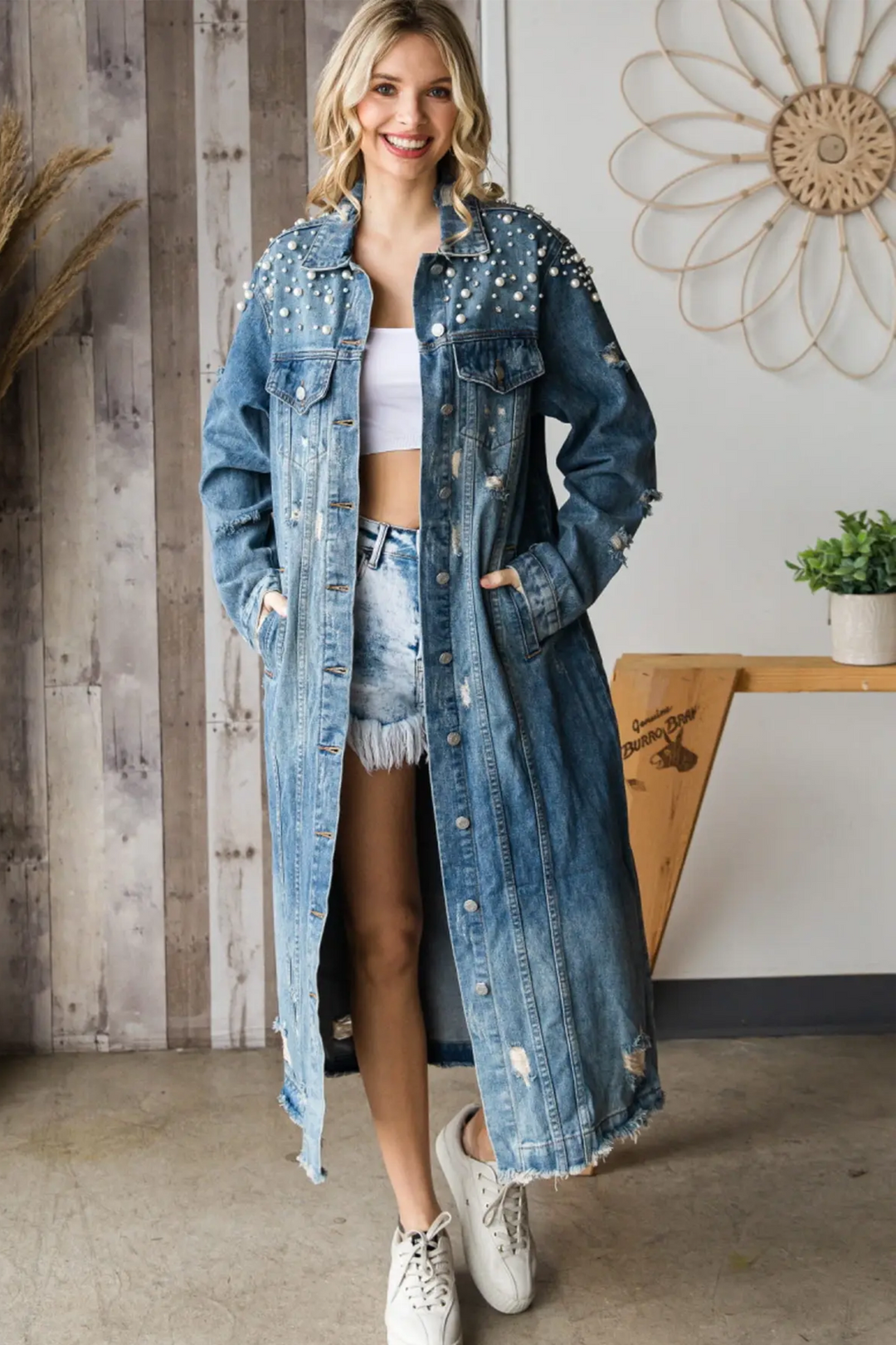Its eye-catching pearl and rhinestone details, stylish distressed tear stitch design patches and long denim coat form a combination of contemporary style and classic comfort.