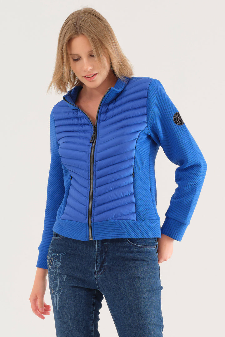 Dolcezza Fall 2025 
 Designed with a high neck zipper for adjustable coverage, its flattering stretchy fit moves with you comfortably. The unique puffy contrast front adds texture and style, while the soft cotton blend ensures everyday comfort. 