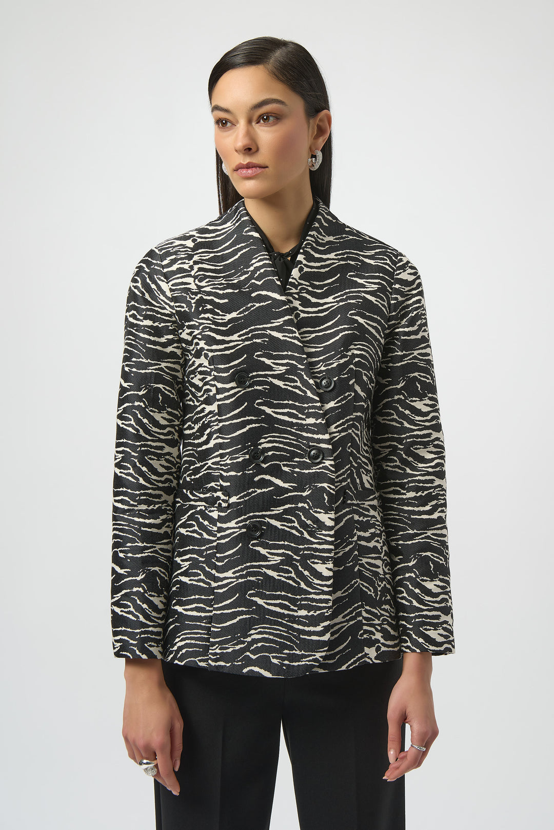 Woman wearing a black and white zebra print jacket on a white background