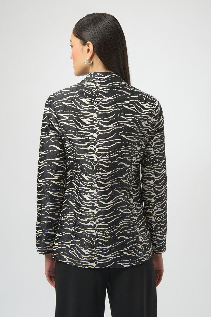 Woman wearing a black and white patterned blazer jacket on a white background