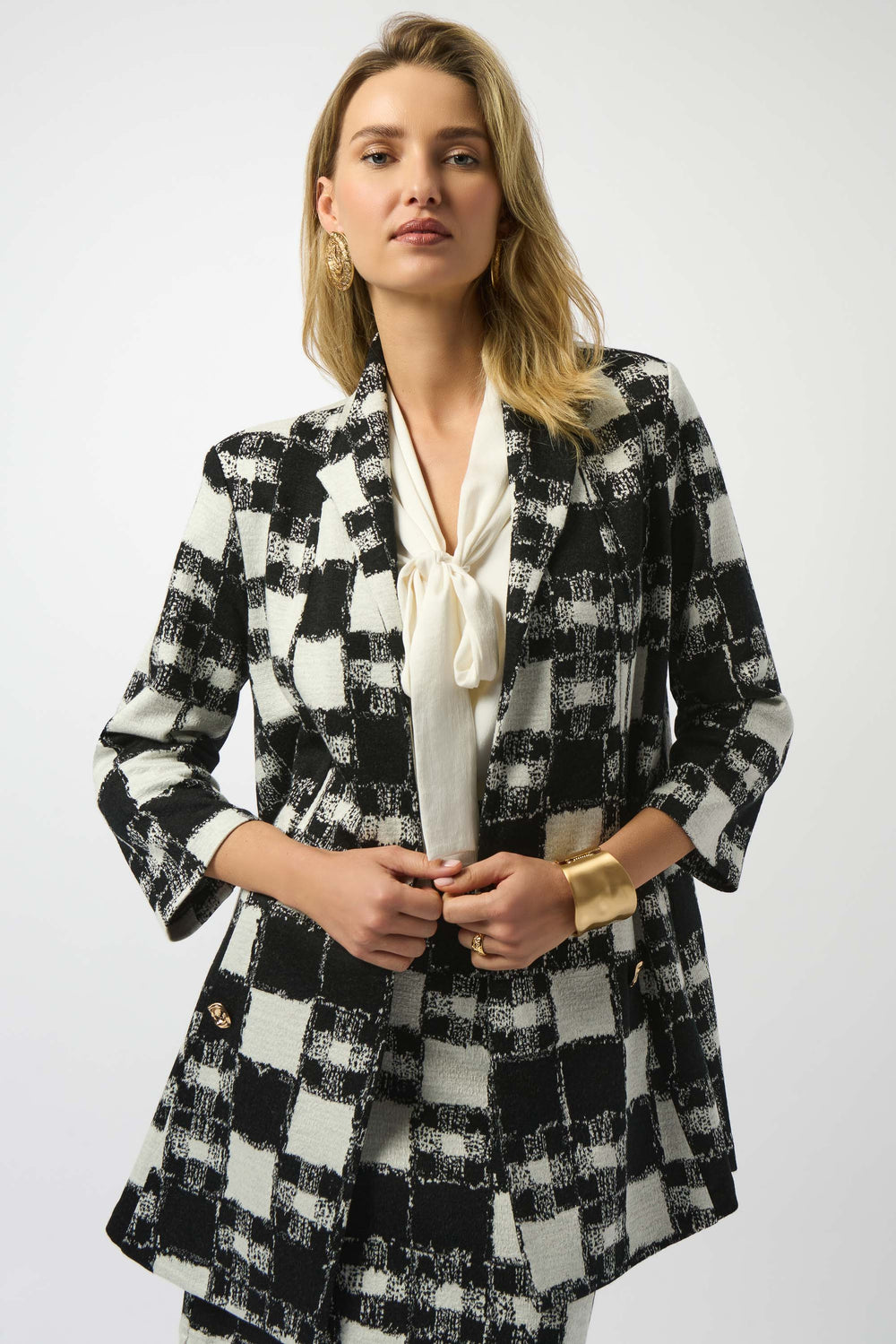 Woman wearing a black and white checkered blazer jacket on a white background