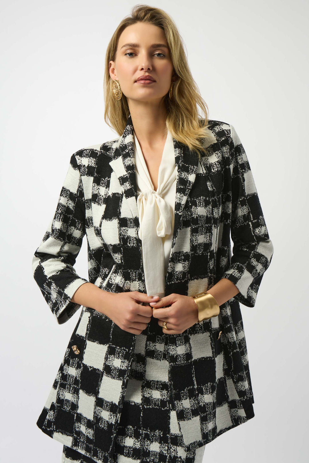 Woman wearing a black and white checkered blazer jacket on a white background