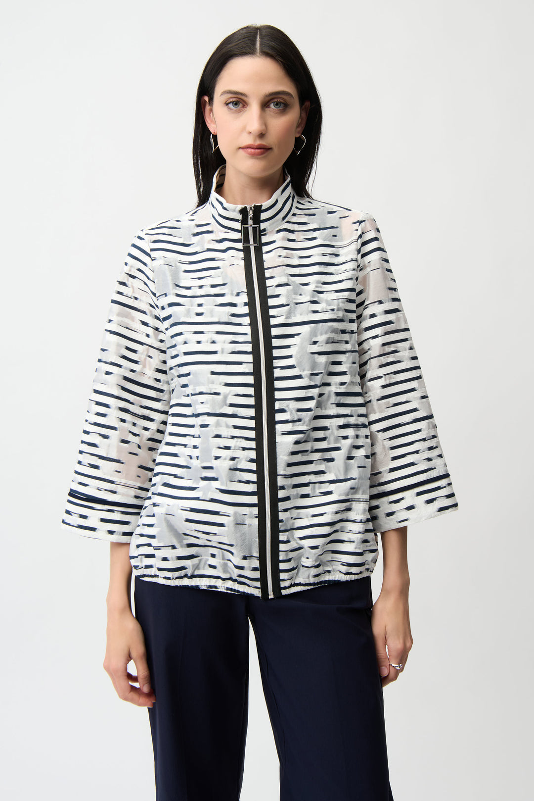 Woman wearing a black and white patterned stripe light jacket on a white background