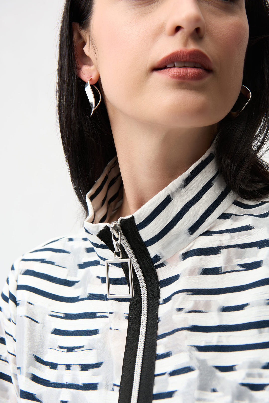 Close-up of a person wearing a striped light jacket with a neutral background
