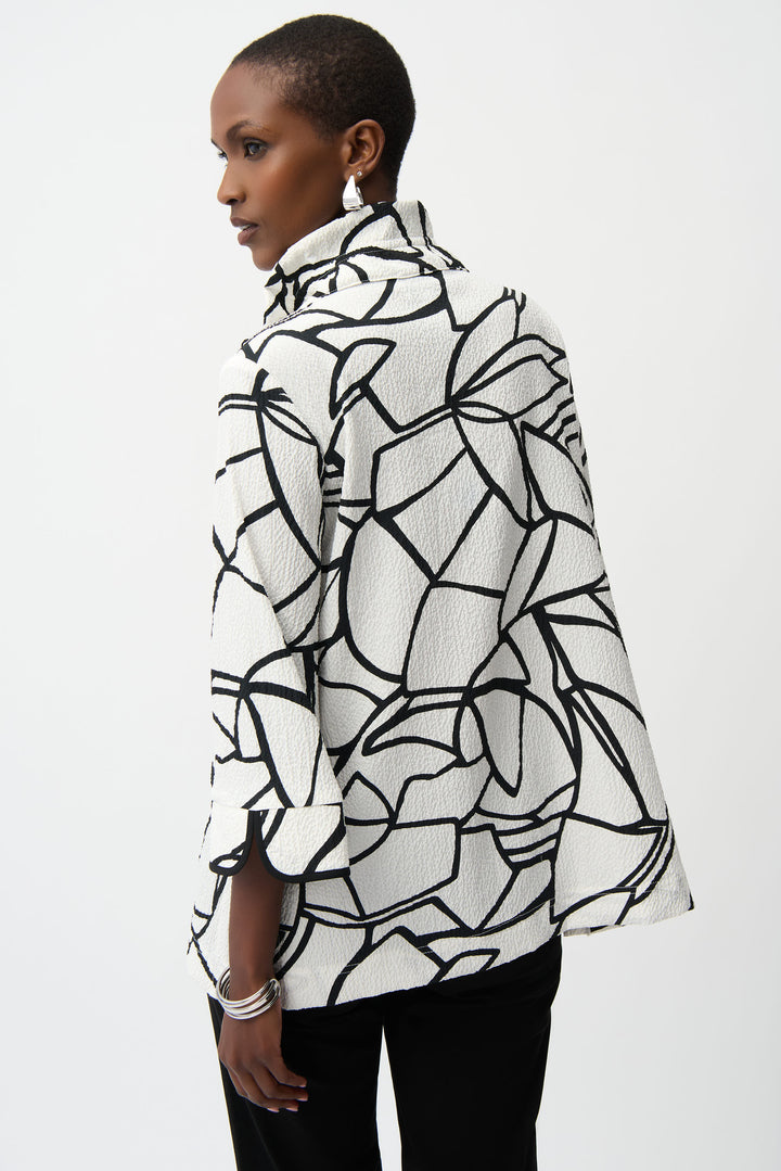 Woman wearing a black and white patterned jacket on a white background