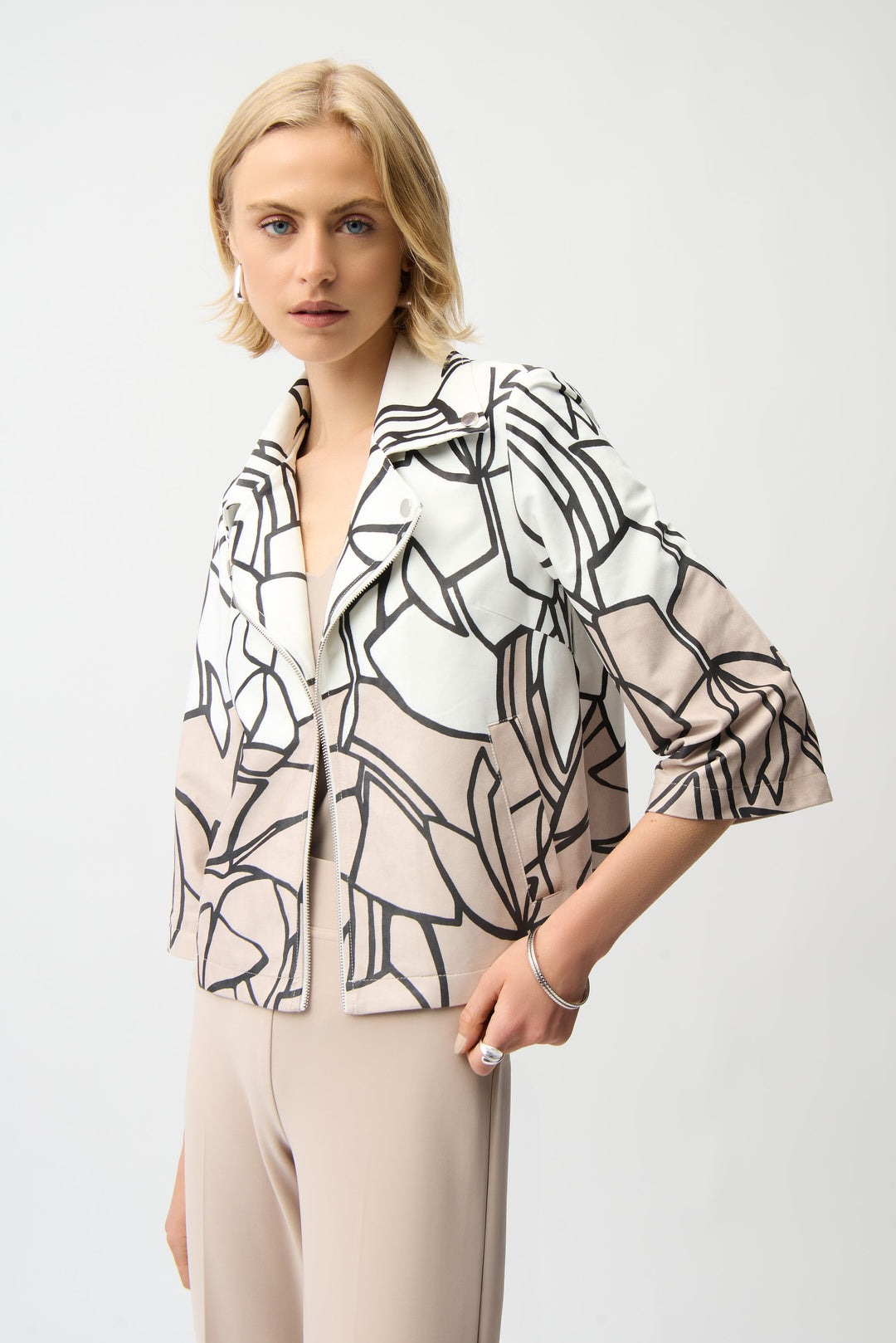 Woman wearing a zip swing jacket with abstract print with a plain background