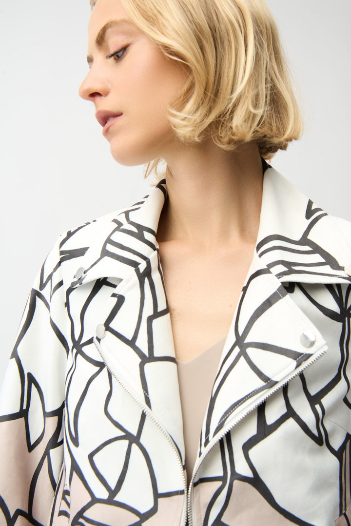 Woman wearing a black and white patterned zip jacket against a plain background