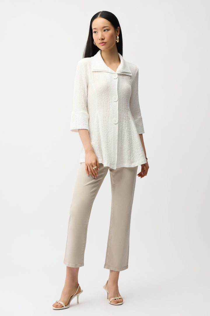 Woman wearing a white blouse and beige pants on a white background