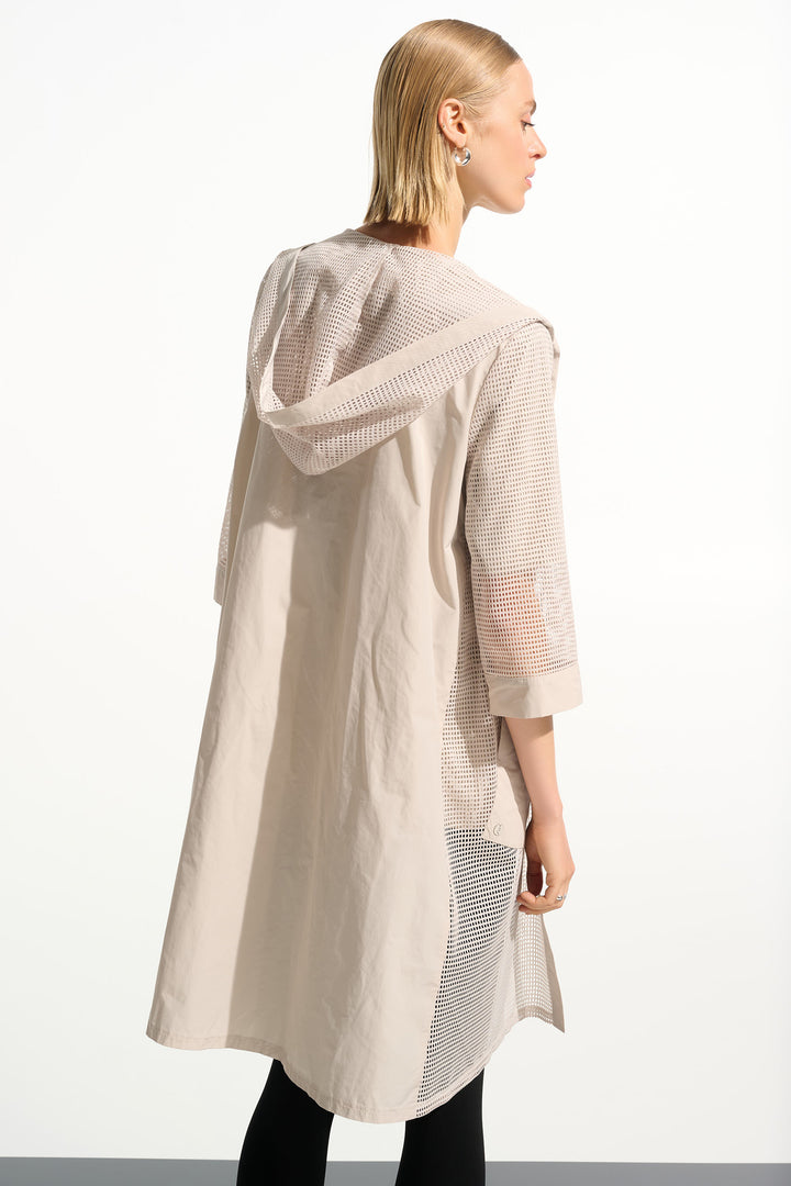 Woman wearing a beige hooded long cardigan on a white background