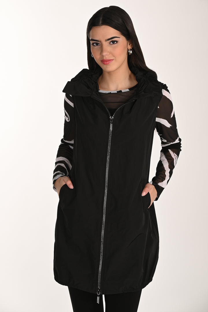 Woman wearing a black zipper vest with patterned sleeves on a white background