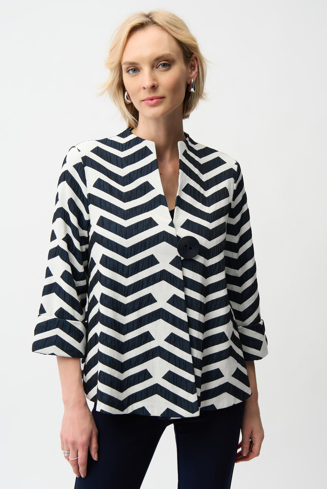 Woman wearing a black and white zigzag patterned jacket on a white background