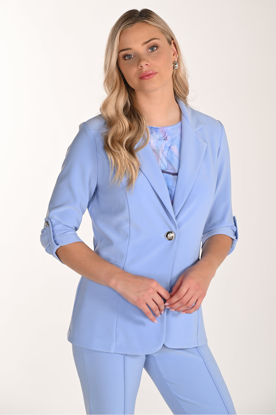 Woman wearing a light blue blazer with single button with a white background