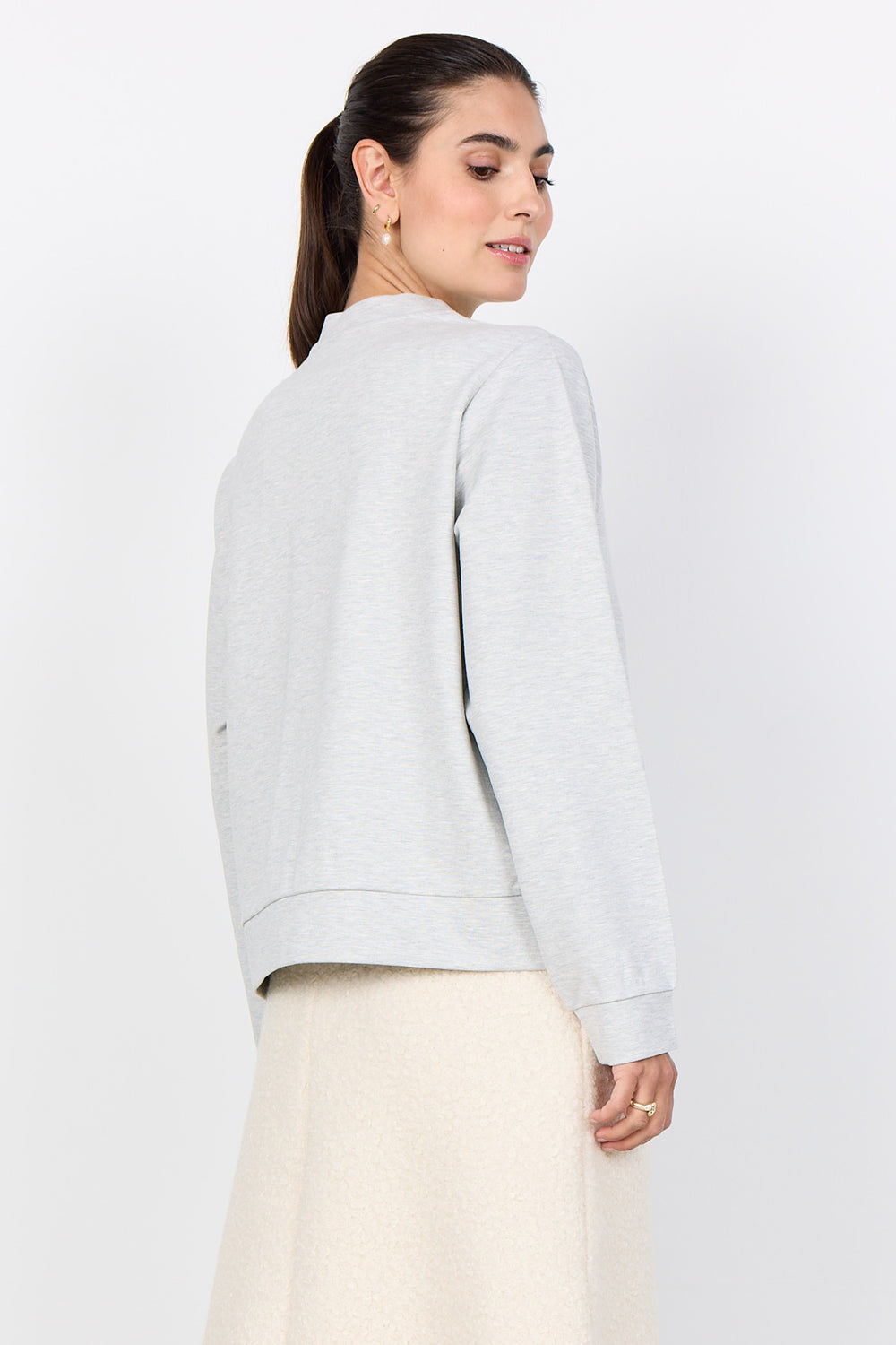 Woman wearing a light gray jacket on a white background