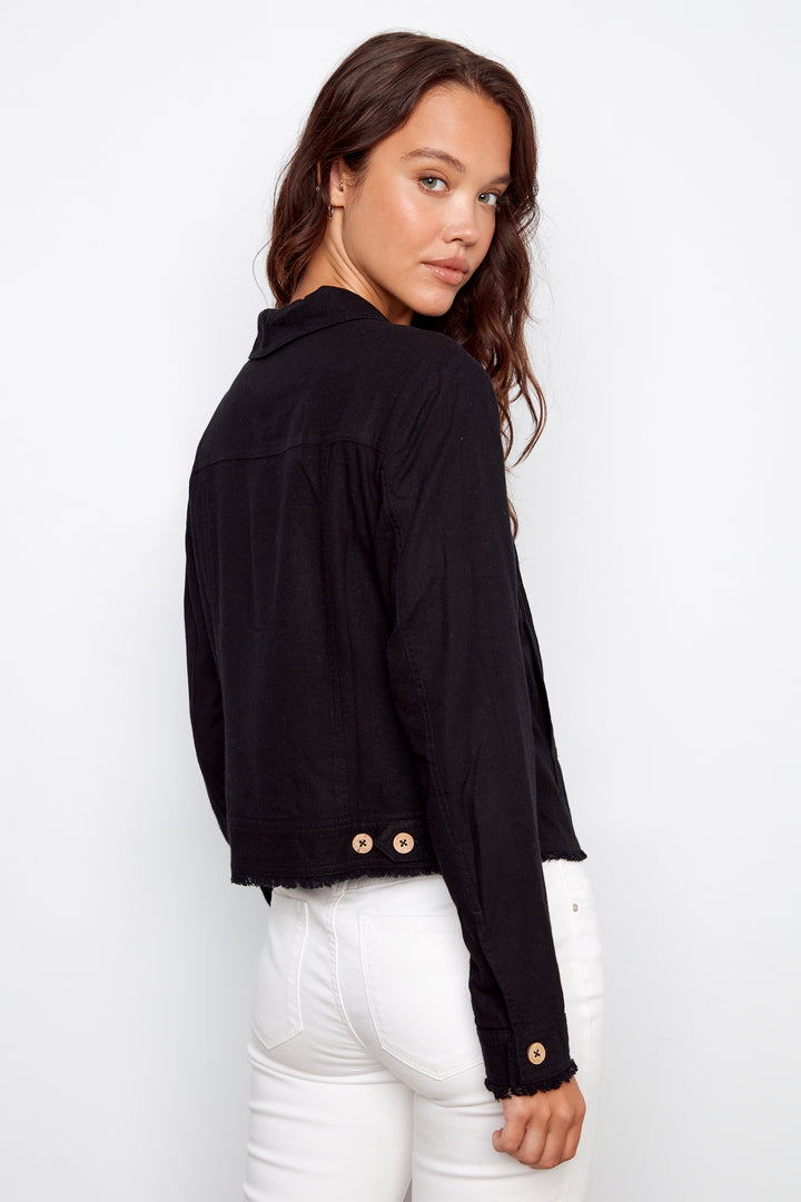 Woman wearing a black jacket with gold buttons on a white background