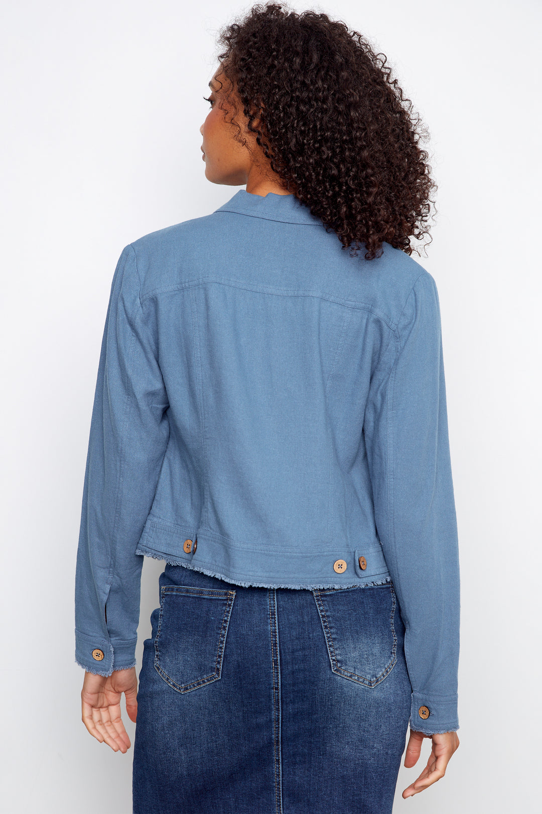Person wearing a blue denim jacket and skirt on a white background