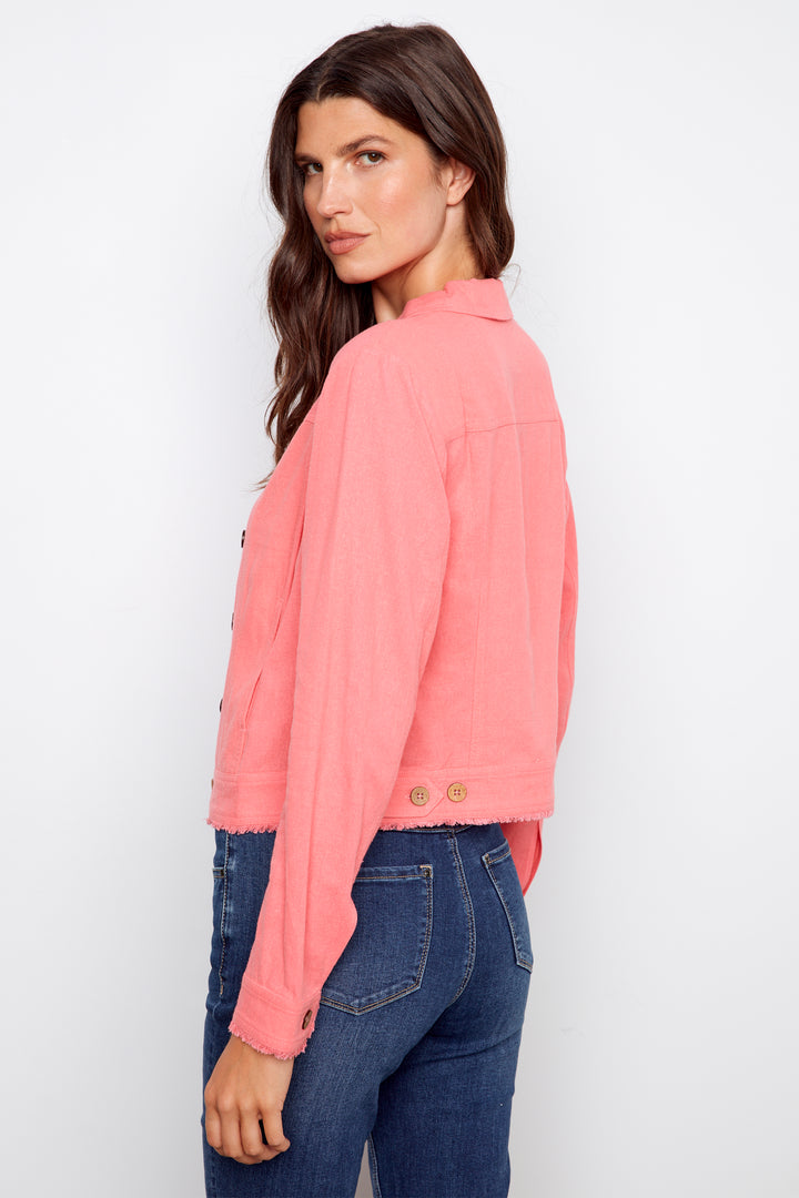 Woman wearing a pink jacket and blue jeans on a white background