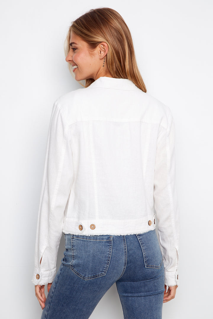 Woman wearing a white blouse with gold buttons and blue jeans on a white background