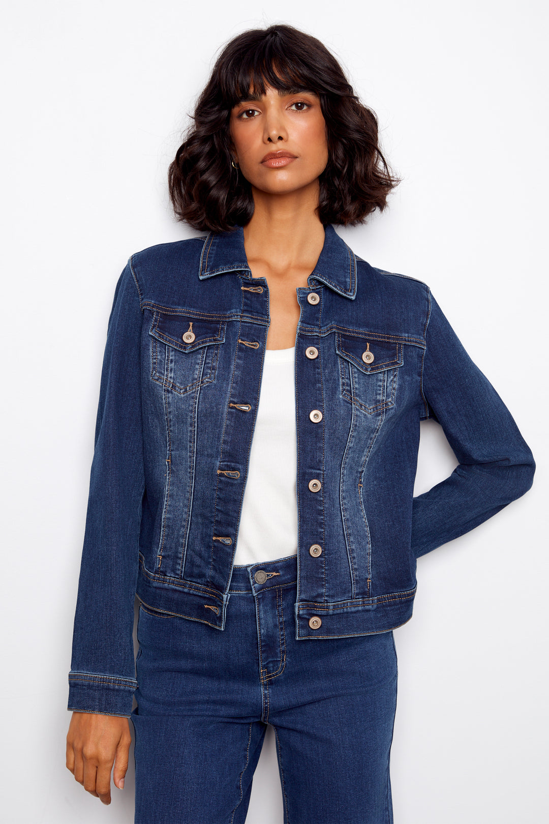 Woman wearing a blue denim jacket and jeans on a white background