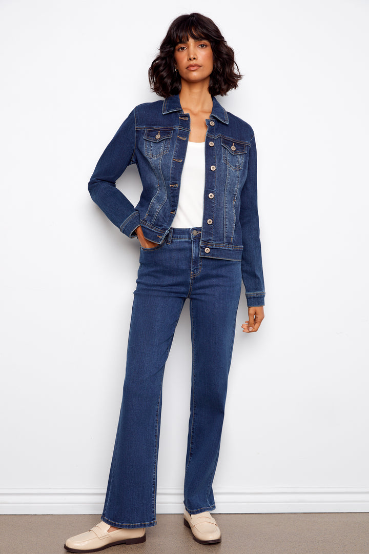 Woman wearing a blue denim jacket and jeans against a white background