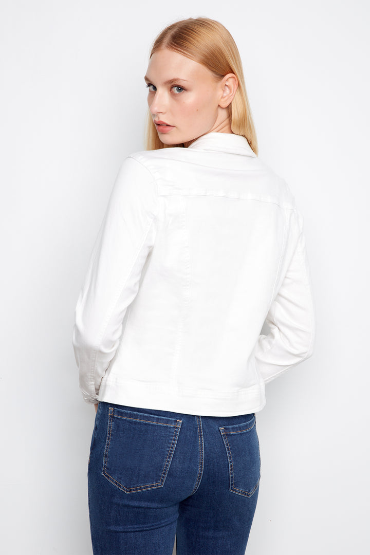 Woman wearing a white shirt and blue jeans against a plain background