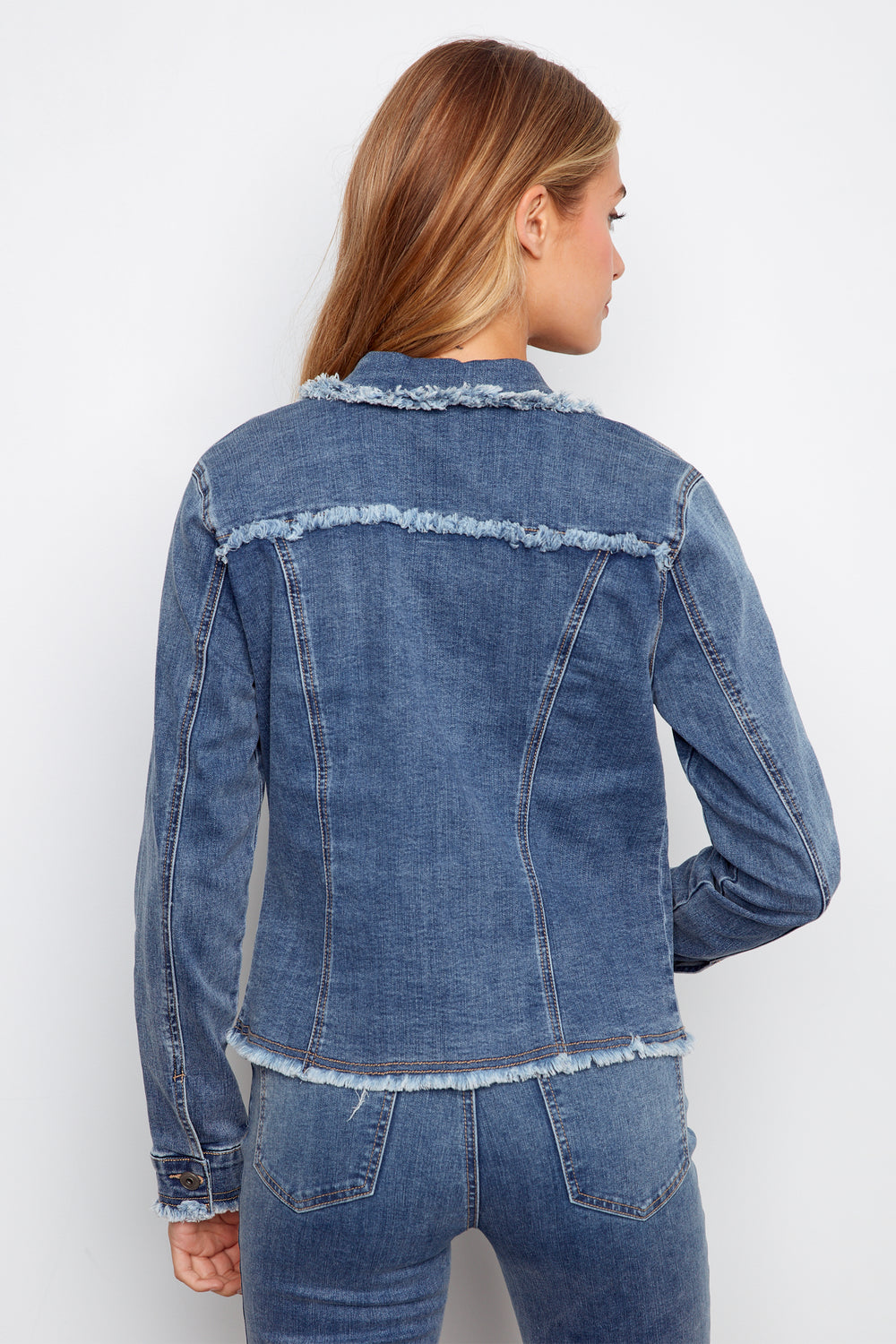 Person wearing a blue denim jacket on a white background