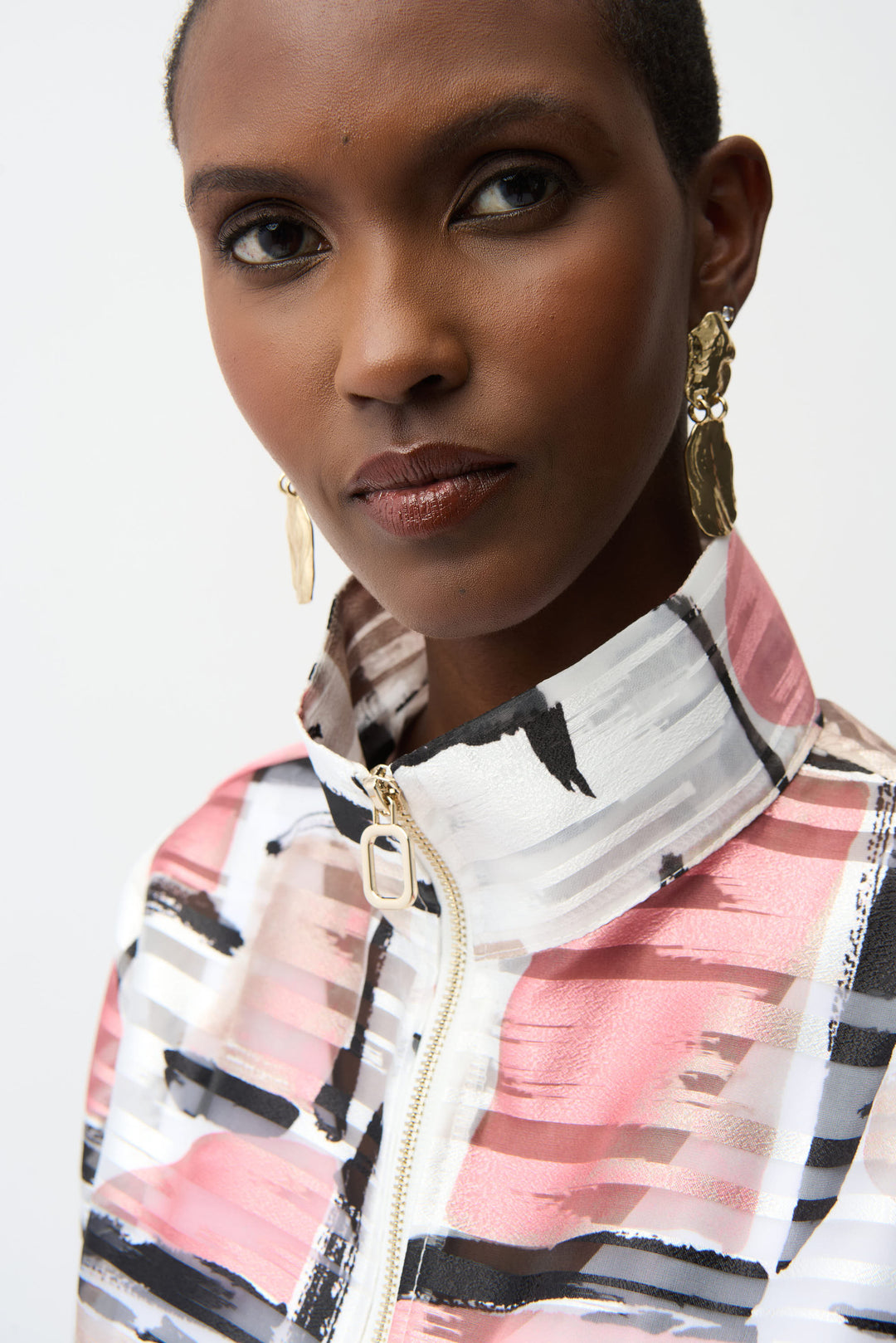 Woman wearing a patterned jacket with a plain background