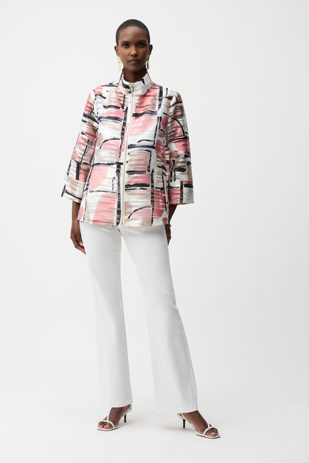 Person wearing a patterned jacket and white pants on a white background