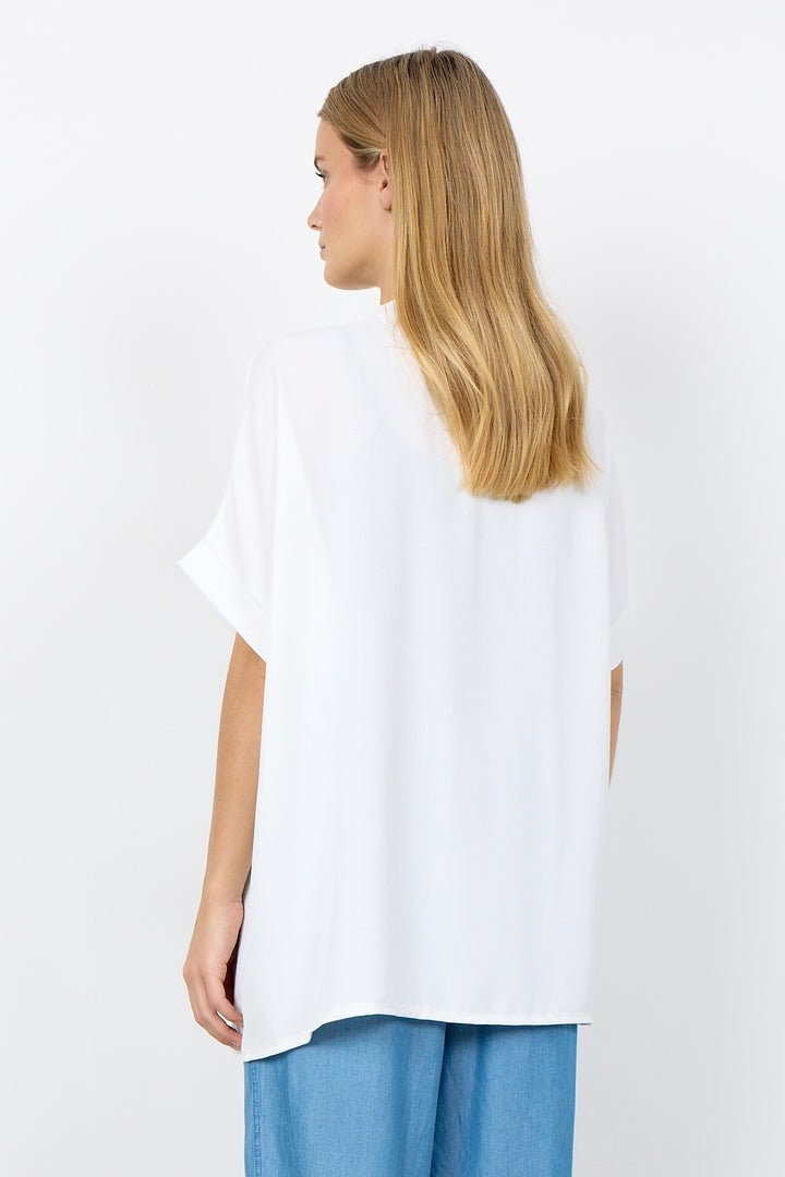 Woman wearing a white blouse and blue pants on a white background