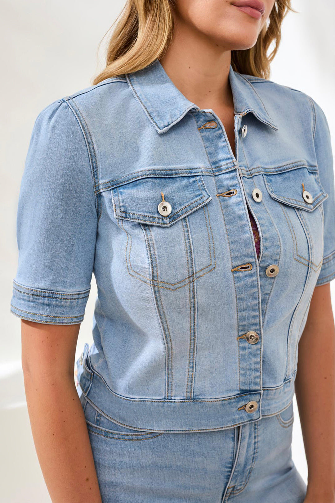 Light blue denim jacket worn by a person on a white background