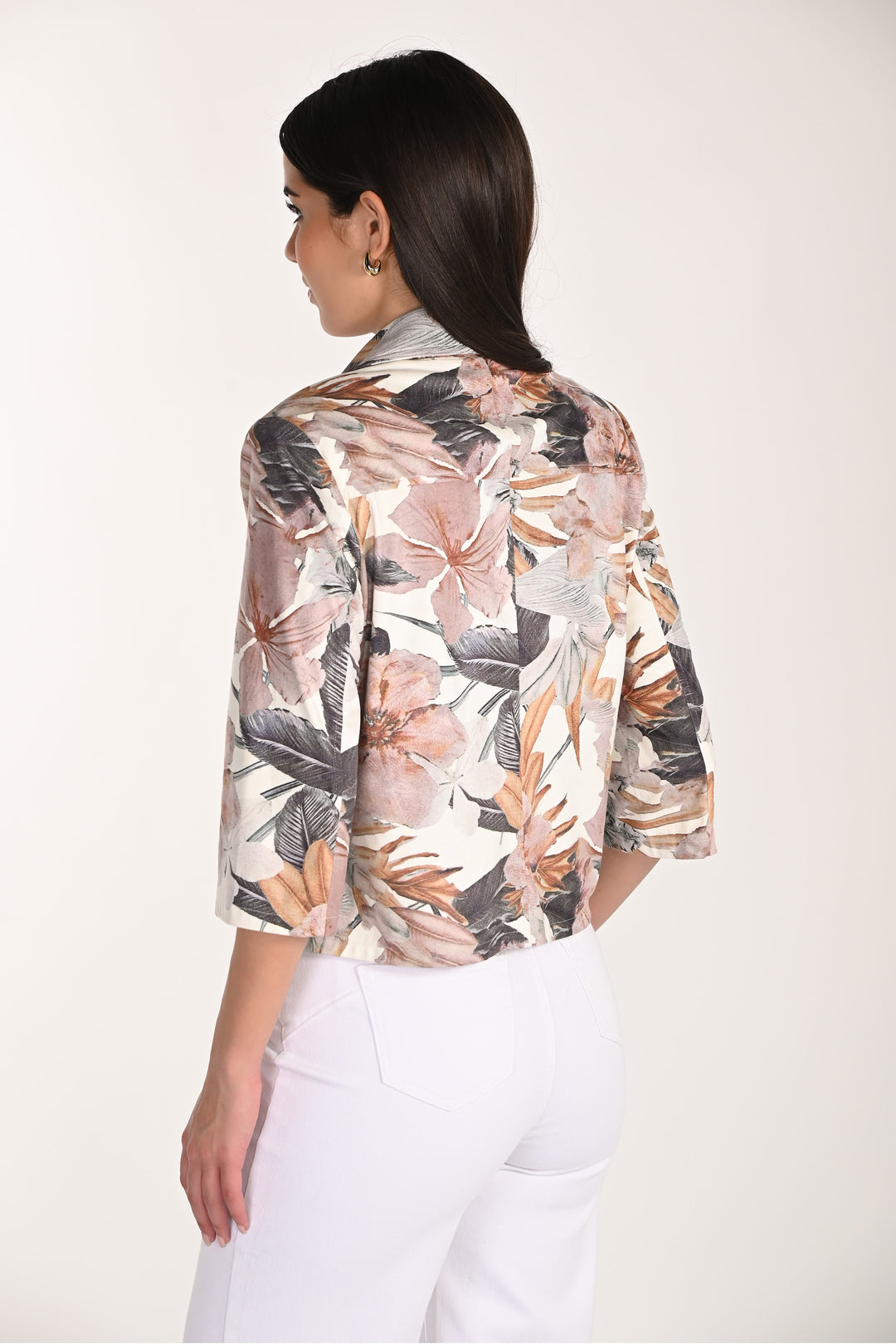 Woman wearing a floral light zipper jacket with a white background