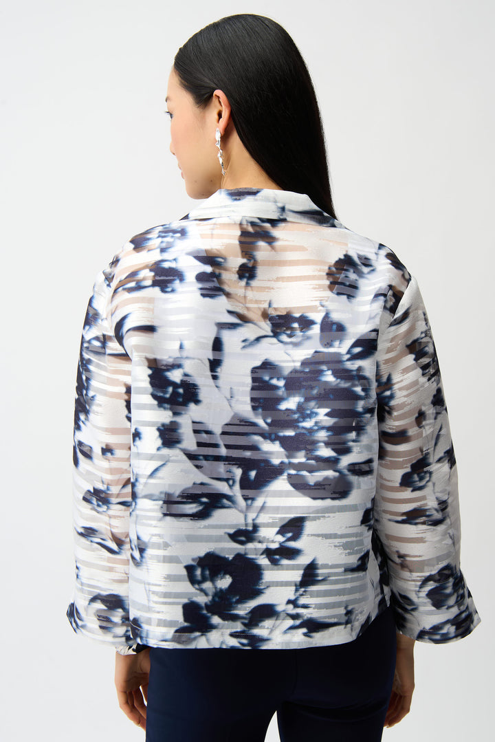 Woman wearing a floral patterned sheer shirt jacket against a white background