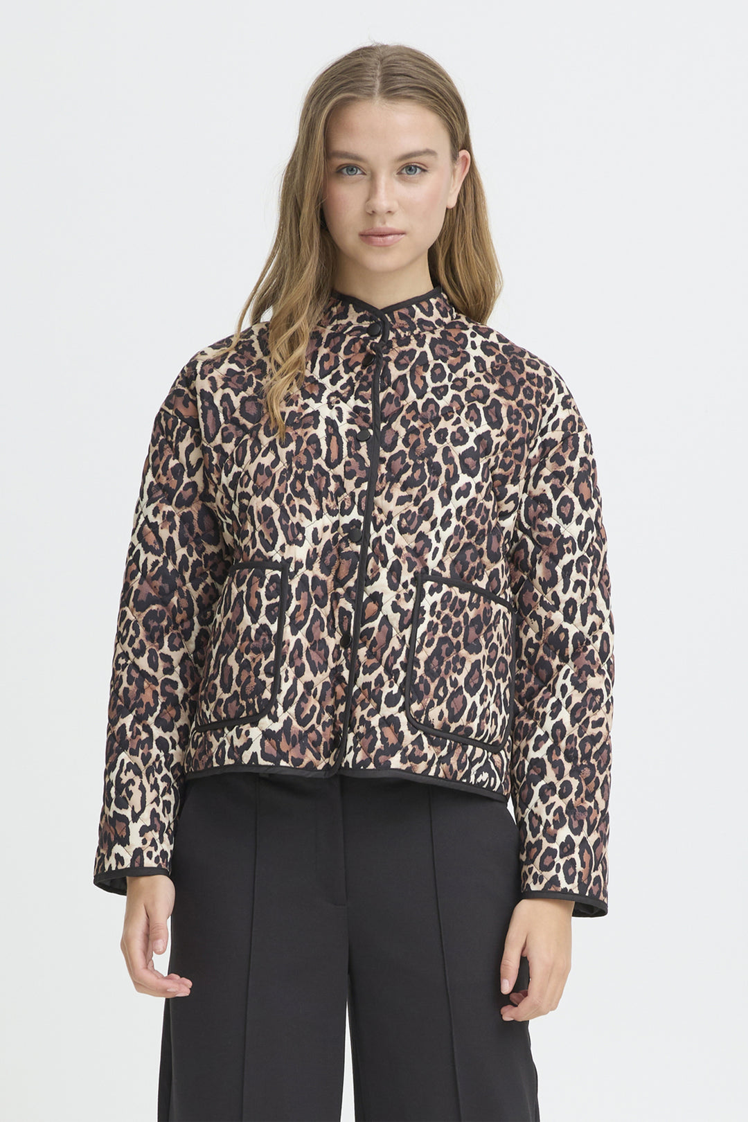 Person wearing a leopard print jacket on a plain background